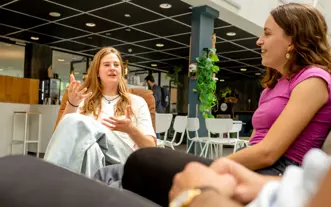 Twee meiden in gesprek in atrium