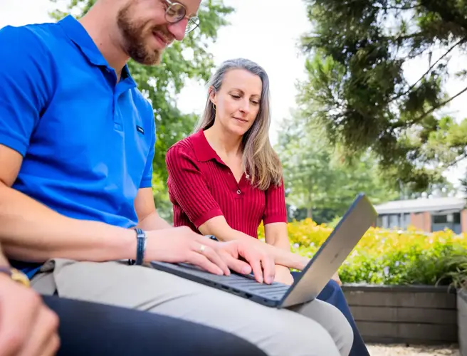 Man laptop op schoot plus vrouw
