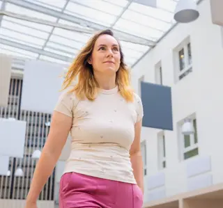 Jonge vrouw roze broek door atrium
