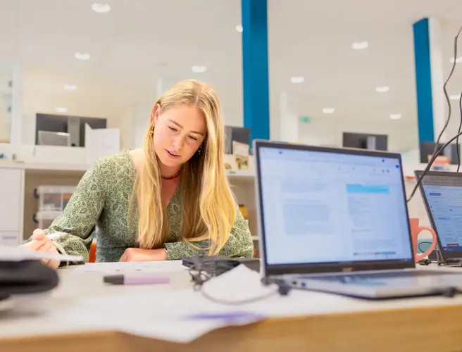 Jonge vrouw lang haar studerend in studiecentrum