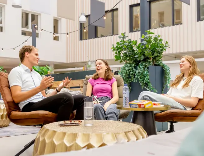 Lachende meiden plus jongen bij zithoek cheers