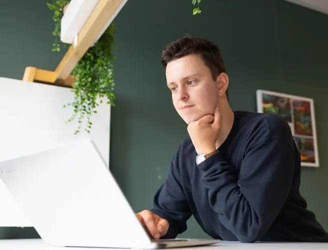 Mannelijke student achter laptop