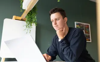 Mannelijke student achter laptop