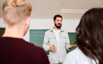 Docent met baardje legt uit