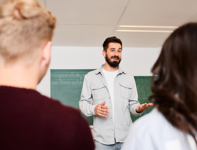 Docent met baardje legt uit