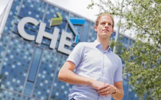 Man bij CHE logo aan prisma