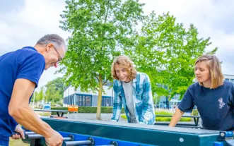 drie mensen bij tafelvoetbaltafel