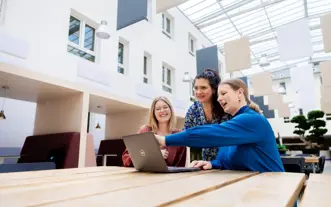 Drie dt vrouwen in atrium laptop