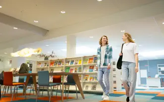 Twee studenten lopen door studiecentrum m en v